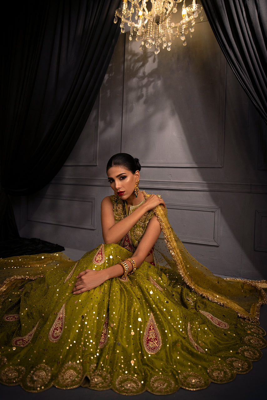 Pakistani couture bridal lehenga in olive gold featuring artisanal embellishments and timeless wedding elegance.