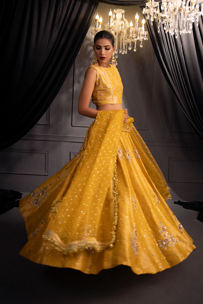 Zarmina marigold-yellow bridal designer lehenga showcasing intricate embroidery, fluid drape and elegant flare.