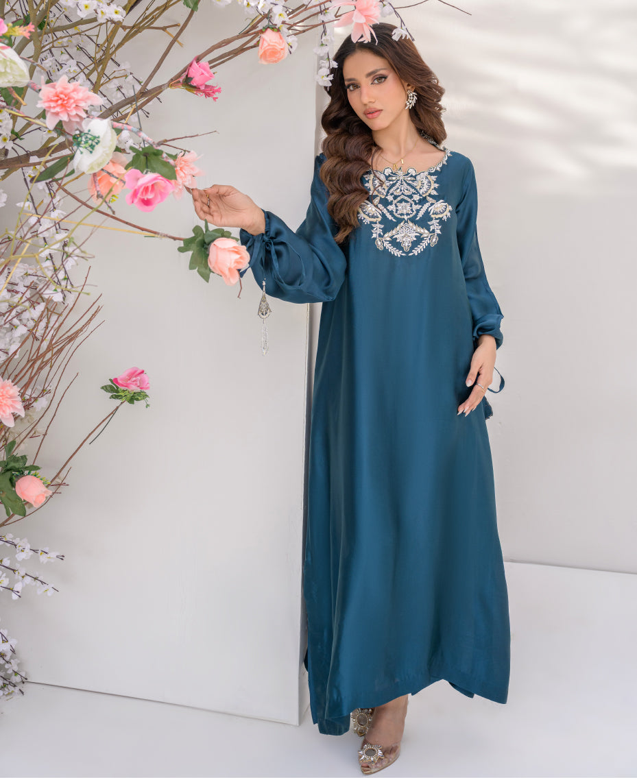 Teal sheesha silk long shirt with gold kora dabka embroidery on neckline, paired with wide-leg pants, featuring pearl and gold tassels for a luxurious festive look.